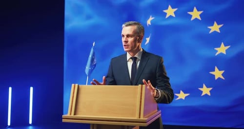 Man Giving Speech at Podium with EU Flag
