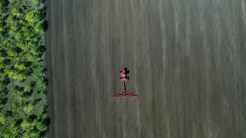 Tractor Plowing the Land, View From the Copter. Modern Agricultural Machinery Processes the Land for