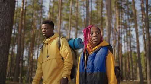 Afroamerican Couple Hiking Trekking in Forest with Backpacks Enjoying Their Adventure Tourism