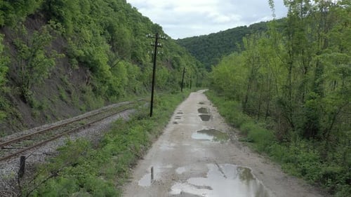 Parallel railroad track and dirt road in the wild 4K drone video