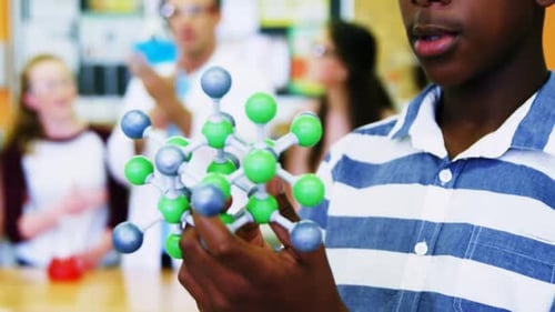 Close-up of schoolboy examining molecule model