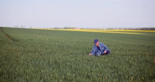 Agronomist Examining Crops And Using Digital Tablet On Field
