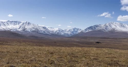 Timelapse of Sun Movement on Crystal Clear Sky with Clouds Over Snow Mountain Top