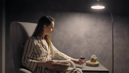 Woman Relaxes Knitting and Drinking Wine Indoors