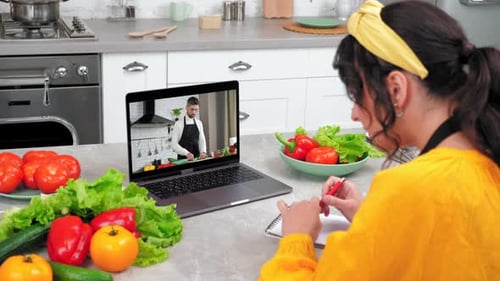 Mujer en casa cocina estudio videollamada en línea webcam portátil le dice a chef profesor