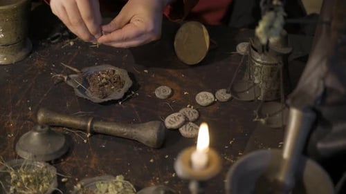 Herbalist weighing dried herbs using old scale