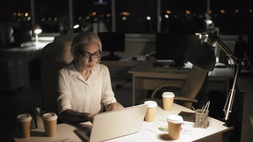 Middle-Aged Office Employee Working Overtime Late at Night