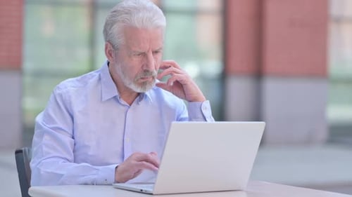 Senior Man Works on Laptop in Outdoor Setting
