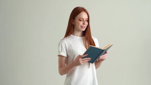 Young Woman Reads a Book Indoors