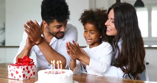 Joyful Family Celebrates Birthday with Cake Indoors