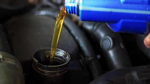 Pouring Fresh Golden Oil Into a Car Engine