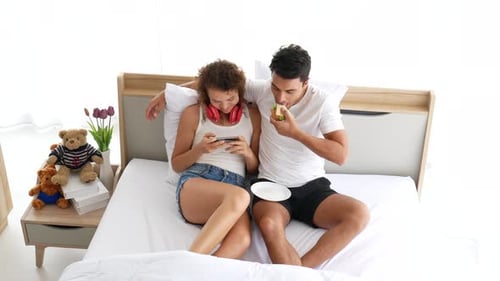 Couple Relaxing Together in Bed at Home