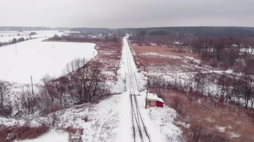 Chemin de fer entouré de forêt en hiver, vue aérienne par Drone