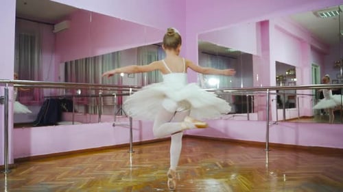 Ballerina dancing in studio in front of mirror. In the ballet hall. A little dancer.