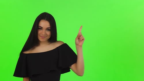 Smiling Woman Points to Side on Green Screen