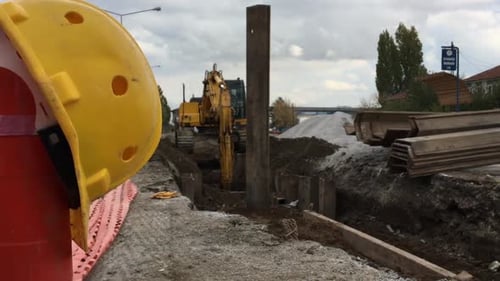 Excavator Places Steel Beam at Construction Site