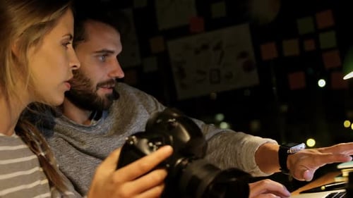 Two People Look at a Laptop in an Office