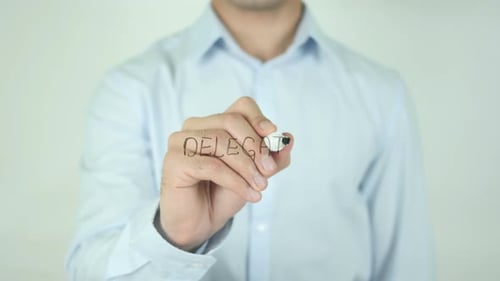 Man Writes Word Delegate on Transparent Screen