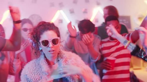 Friends Dancing at an Energetic Party with Neon Lights