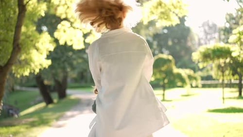 Joyeuse femme caucasienne filant une petite fille au Ralenti dans un parc ensoleillé