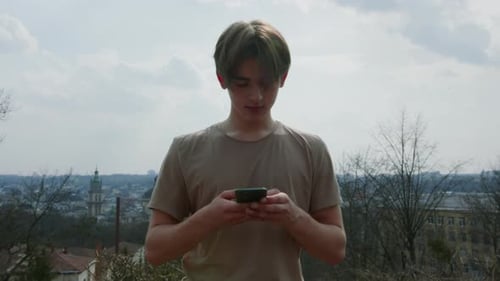 Young Adult Using Phone in Urban Setting