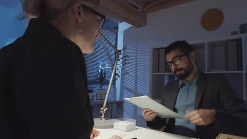 Male and Female Colleagues Discussing Business Project in Office