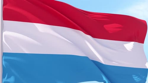 Luxembourg Flag Waving in Slow Motion Against Blue Sky