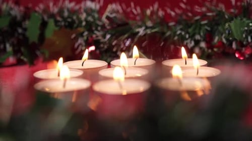 Candles Burning with Garland Decoration on Red Background