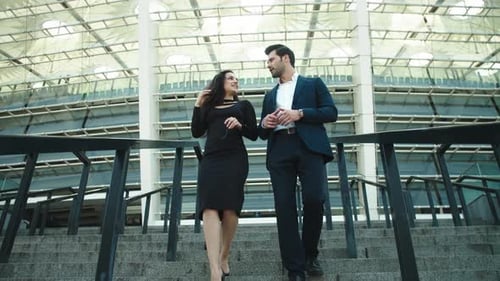 Two Business Partners Going Down at Stairway Near Modern Building