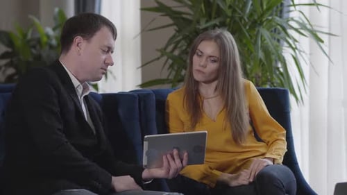 Business Meeting Concludes with Handshake on Digital Tablet
