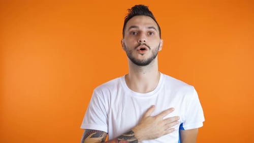 Male Football Soccer Fan Singing Hymn Hand on His Heart. Studio Shot. Patriotism Concept