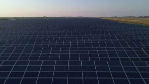 Drone Close Up Flies Over Large Solar Panels at a Solar Farm at Sunny Summer Evening