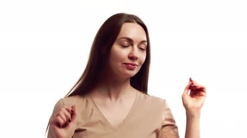 Beautiful Woman Smile and Looks Into Camera and Adjusts Long Lush Hair on White Background in Studio