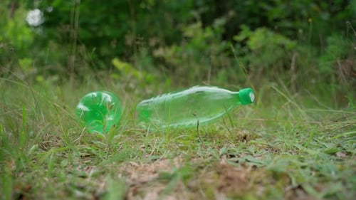 Pollution of surrounding atmosphere and nature by humanity. Dump of plastic bottlesgarbage in forest
