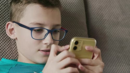Child Focused on Smartphone at Home