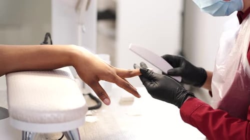 Manicurist Filing Nails in a Bright, Clean Salon