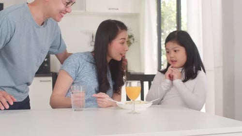 Family Eating Pasta at Kitchen Table