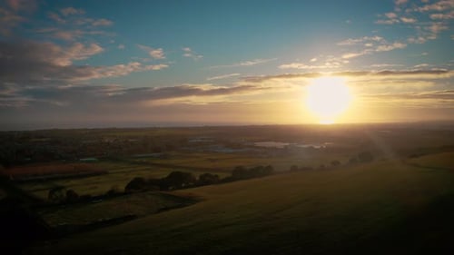 Golden Sunrise over Rolling Hills Landscape Aerial