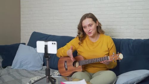 Mujer imparte clases en línea enseñando a los estudiantes a tocar el ukelele