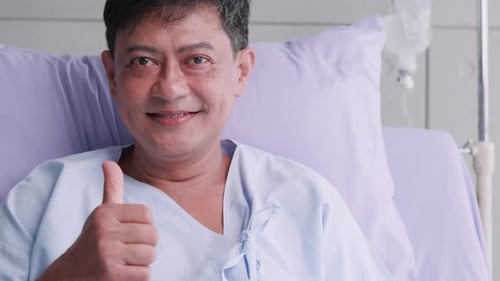 Happy elderly Asian male patient trust hospitalization.