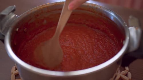 Stirring Thick Tomato Sauce in Silver Pot