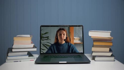 Woman on Laptop Screen with Stacks of Books
