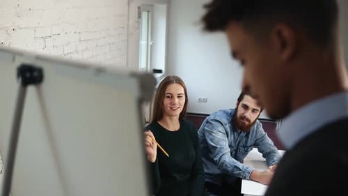 Back View of African American Office Worker Giving Presentation for His Colleques in Office on