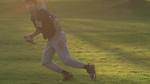 A young man playing catch with a baseball.