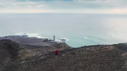 Mann joggt den Bergweg des Vulkans Capelinhos hinunter, Insel Faial, Azoren