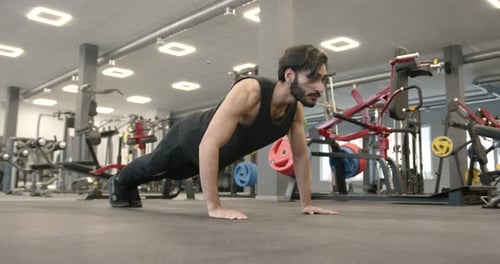 Athletic Man Doing Push Ups at Modern Gym