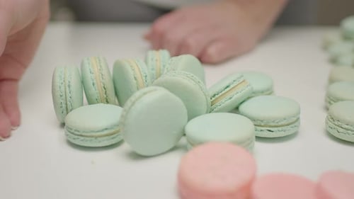 Hands Arranging Colorful Macarons Close Up