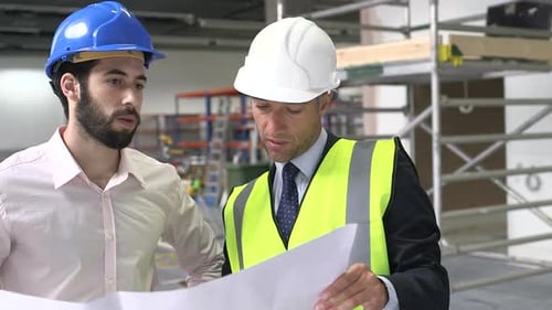 Engineers Reviewing Blueprints at Construction Site