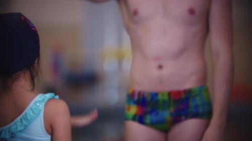 Young Swimmer Training with Adult in Pool