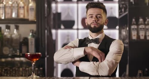The Bartender Is Crossing Arms and Looking in the Camera